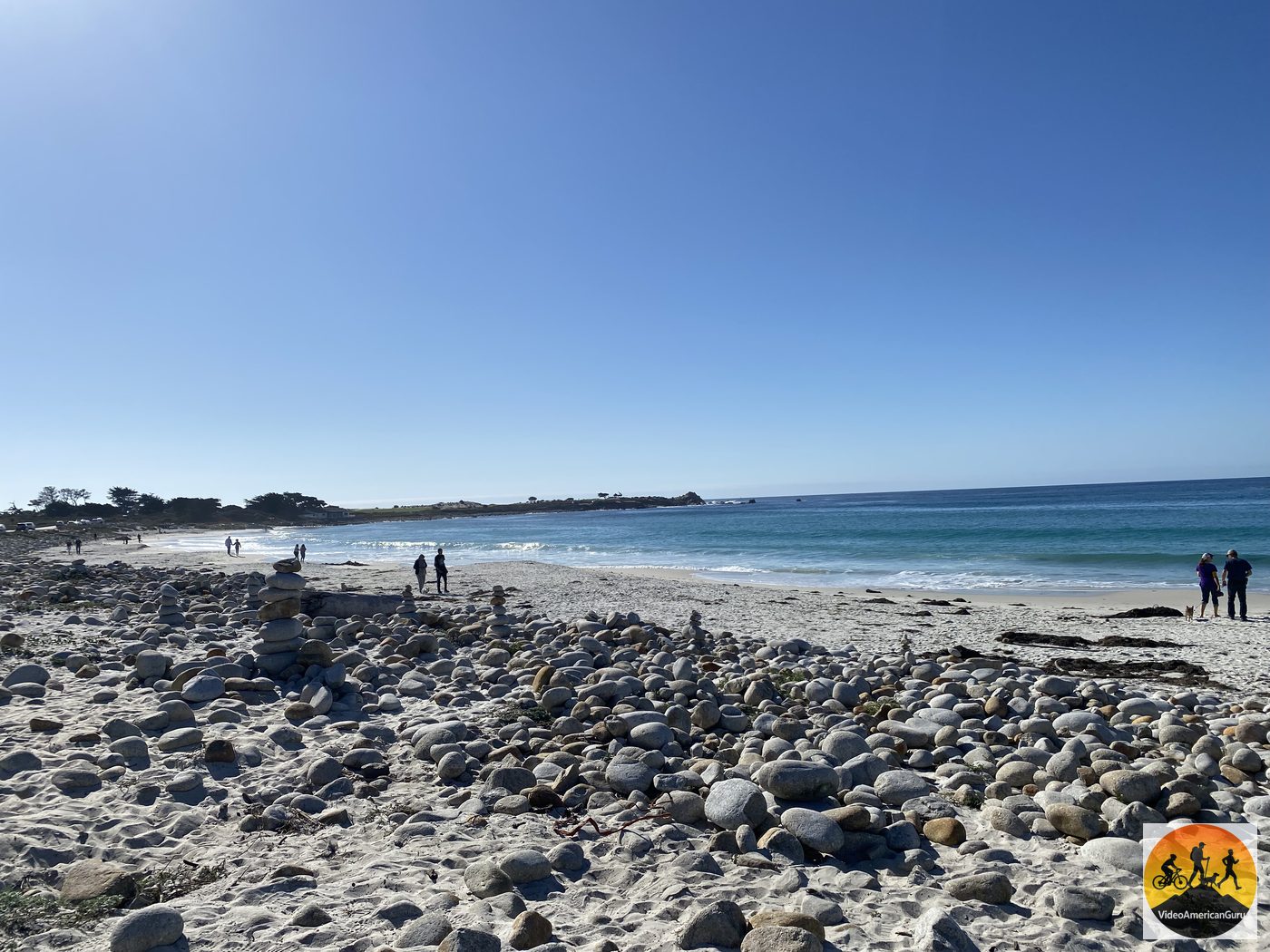 Stone cairns stacked by visitors on the white sand and cobbles of Spanish Bay along 17 Mile Drive